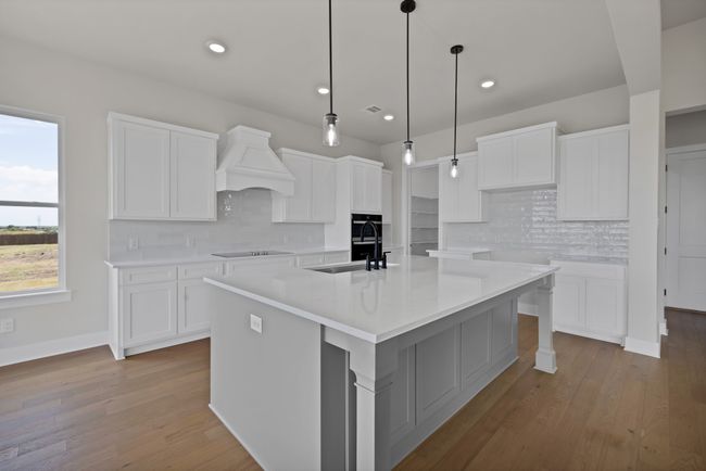 Kitchen with a center island with sink, backsplash, white cabinetry, and recessed lighting | Image 11
