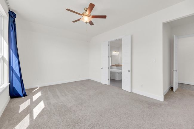 Unfurnished bedroom featuring carpet floors, ensuite bath, baseboards, and a ceiling fan | Image 19