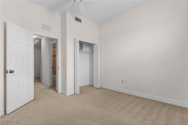 Unfurnished bedroom featuring light carpet, a closet, ceiling fan, and a high ceiling | Image 16