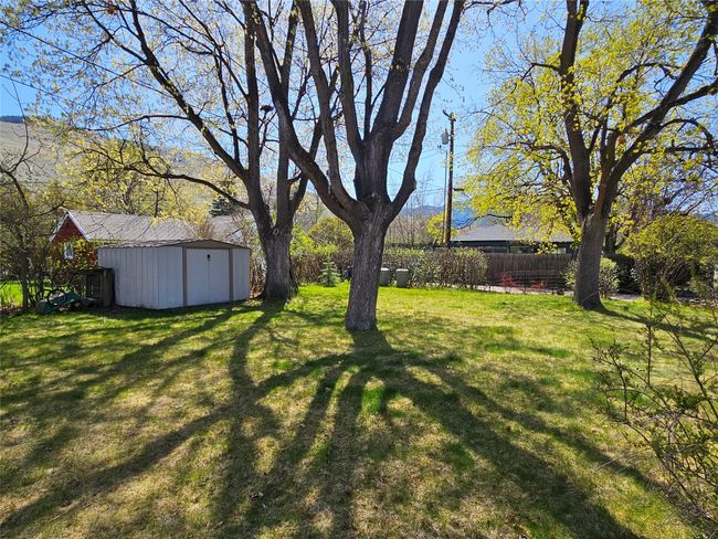 View of yard with fence, a storage shed, and an outbuilding | Image 29
