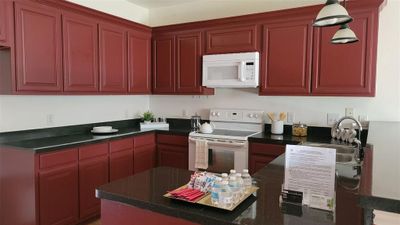 Kitchen featuring decorative light fixtures, white appliances, and sink | Image 3