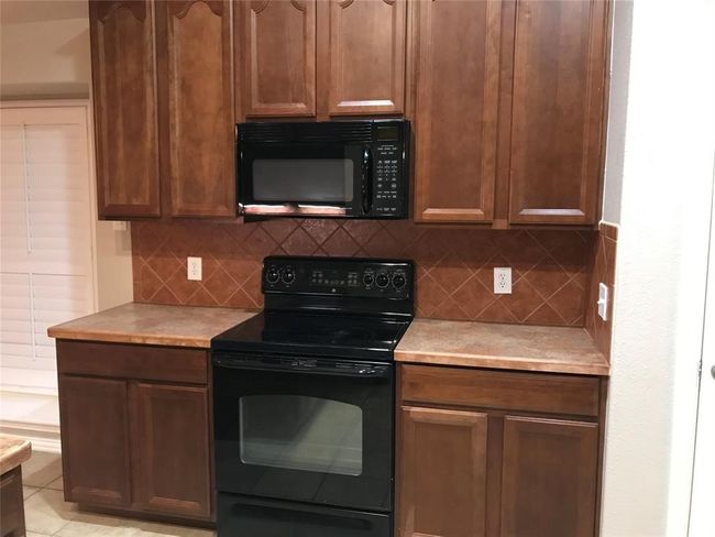 Kitchen with black appliances, tasteful backsplash, and light countertops | Image 8