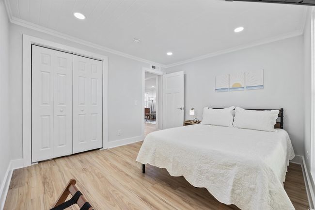 Bedroom featuring recessed lighting, baseboards, light wood-style floors, ornamental molding, and a closet | Image 9
