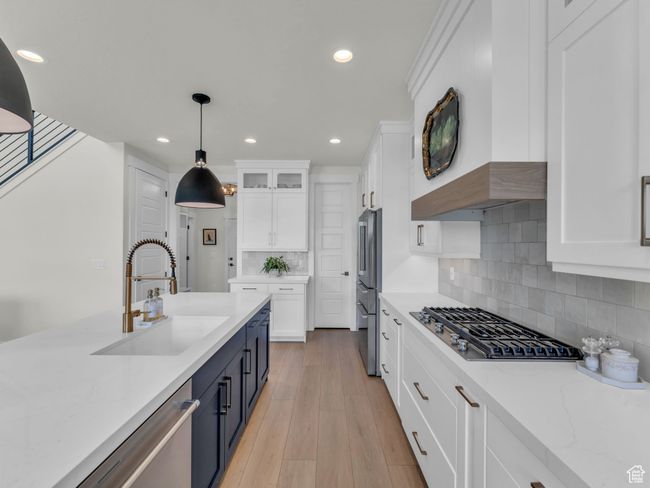 Kitchen with a sink, appliances with stainless steel finishes, white cabinetry, pendant lighting, and recessed lighting | Image 16