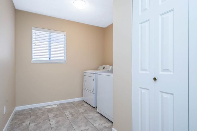 Laundry area featuring baseboards, washing machine and dryer, laundry area, and light tile patterned floors | Image 9
