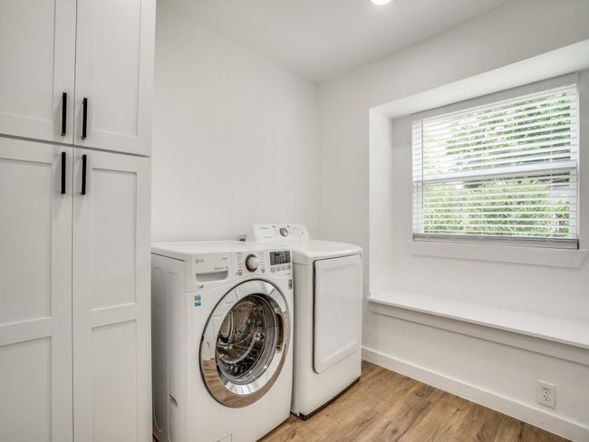 Laundry room with cabinet space, washer and clothes dryer, light wood-type flooring, and baseboards | Image 7