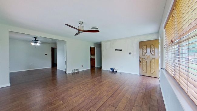 Unfurnished living room featuring ceiling fan, dark wood-style flooring, and baseboards | Image 7
