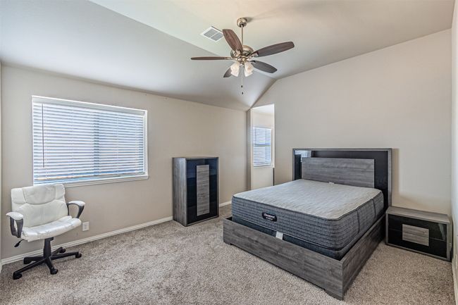 Carpeted bedroom with lofted ceiling, baseboards, and a ceiling fan | Image 36