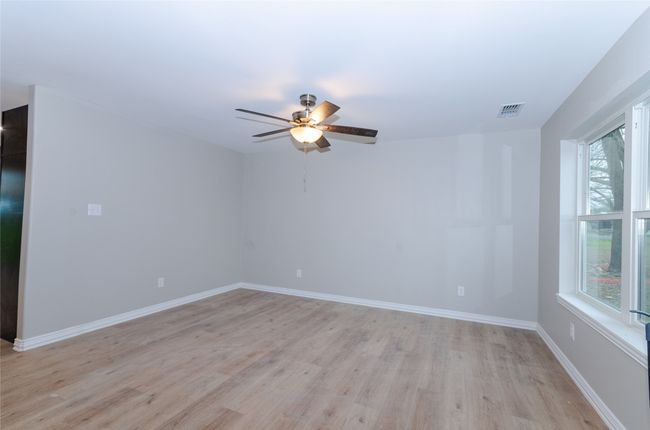 Unfurnished room with a ceiling fan, baseboards, visible vents, and light wood-type flooring | Image 14