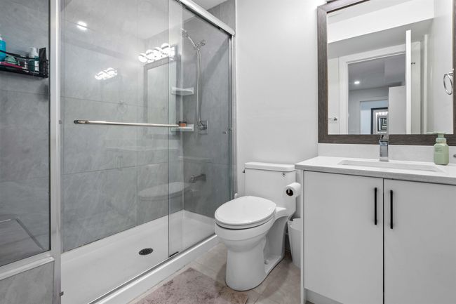 Bathroom with a shower stall, toilet, and vanity | Image 40