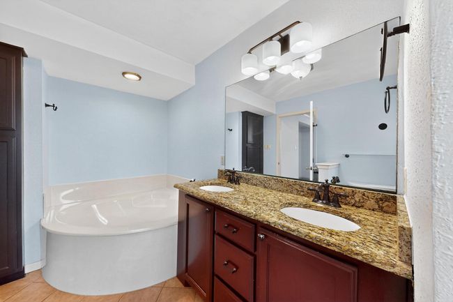 Full bathroom with a bath, double vanity, and tile patterned floors | Image 15