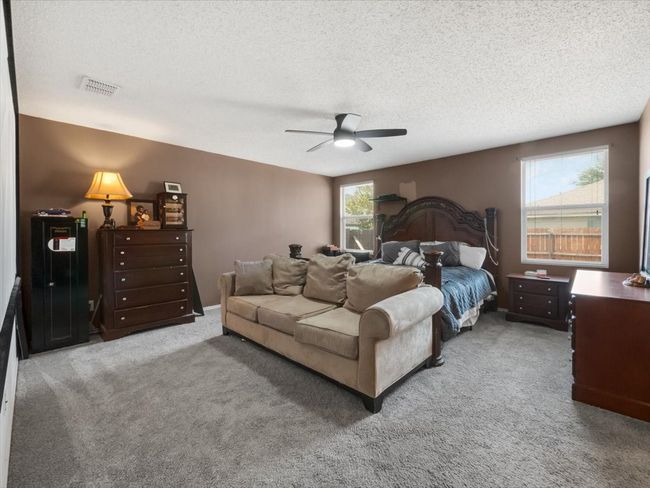 Bedroom with a textured ceiling, ceiling fan, and carpet floors | Image 15