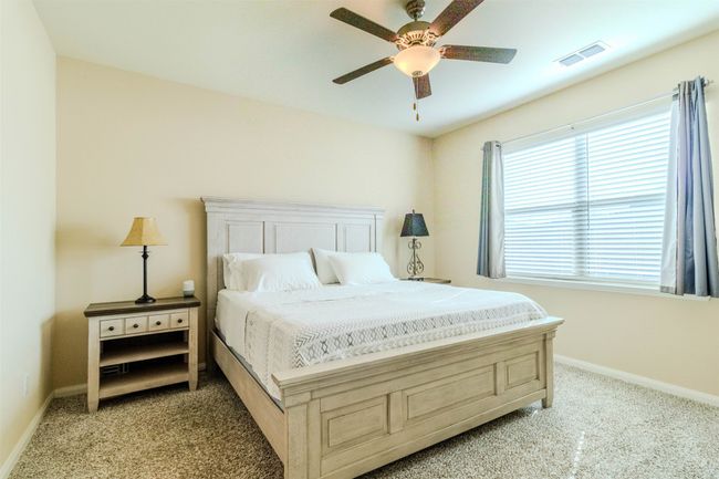 Bedroom with ceiling fan and light carpet | Image 22
