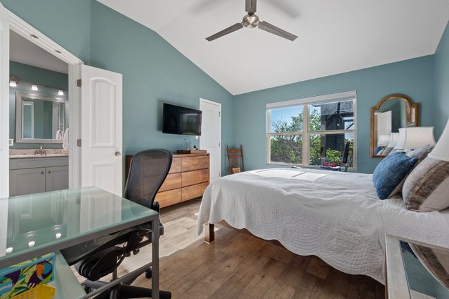 Bedroom with ceiling fan, ensuite bathroom, wood finished floors, a sink, and lofted ceiling | Image 9