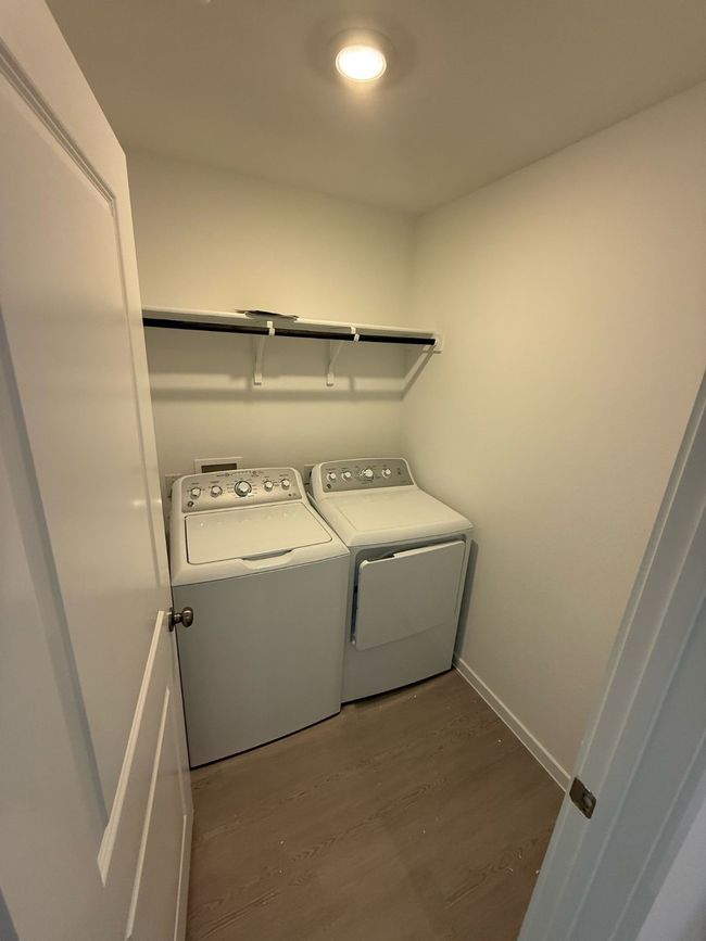 Washroom featuring washing machine and dryer, wood finished floors, and baseboards | Image 19