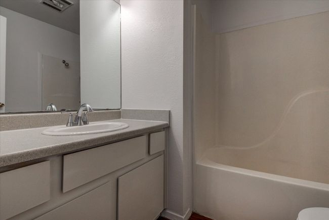 Bathroom featuring bathing tub / shower combination, vanity, visible vents, and toilet | Image 17