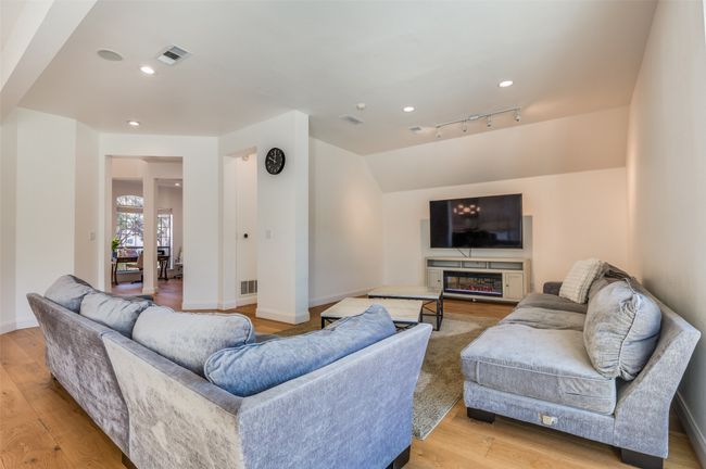 Living area with baseboards, lofted ceiling, visible vents, and light wood-type flooring | Image 19