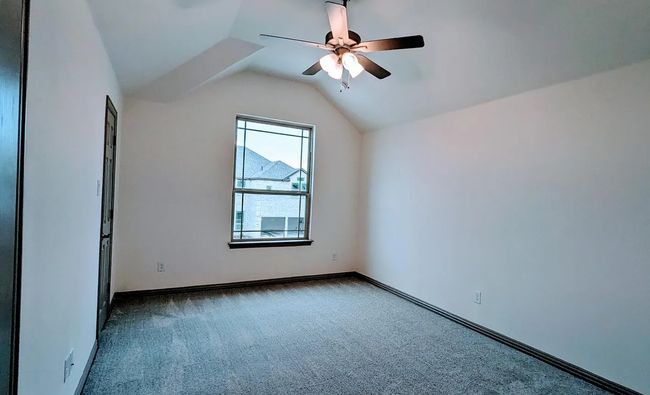 Unfurnished room featuring lofted ceiling, carpet flooring, a ceiling fan, and baseboards | Image 13