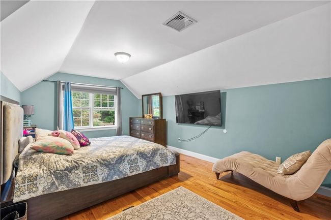 Bedroom featuring wood finished floors, lofted ceiling, and baseboards | Image 22