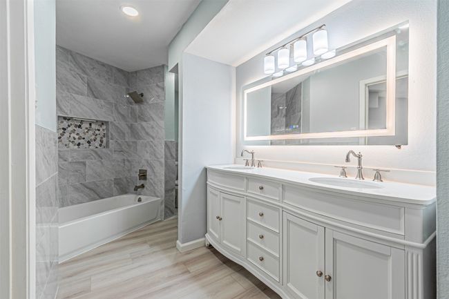 Bathroom with vanity, tiled shower / bath combo, and wood-type flooring | Image 23