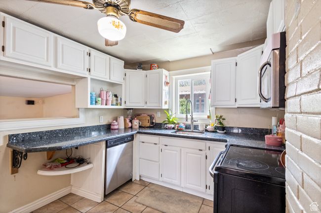 Kitchen featuring stainless steel appliances, a sink, white cabinetry, open shelves, and light tile patterned floors | Image 8