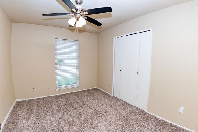 Unfurnished bedroom featuring light carpet, a closet, and ceiling fan | Image 18