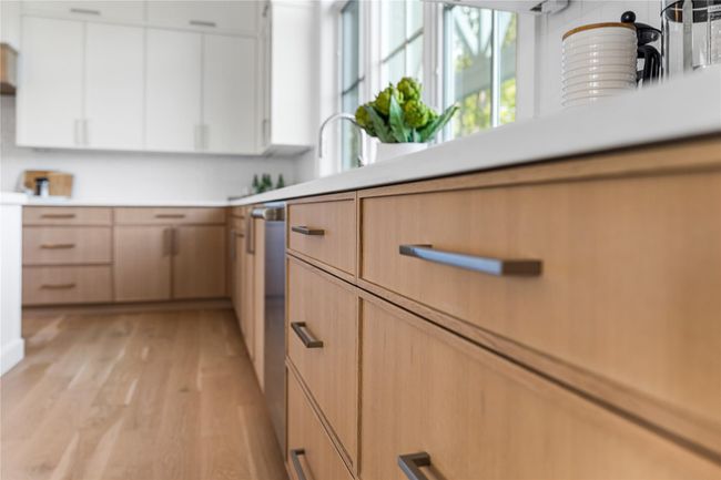 Kitchen with light countertops, light wood-style floors, light brown cabinetry, and white cabinetry | Image 18