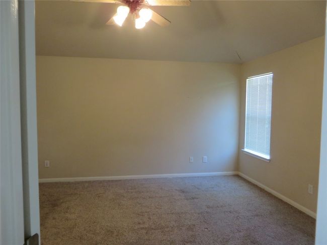 Carpeted empty room with ceiling fan and baseboards | Image 9