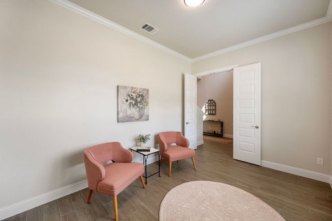 Living area with baseboards, crown molding, and wood finished floors | Image 21