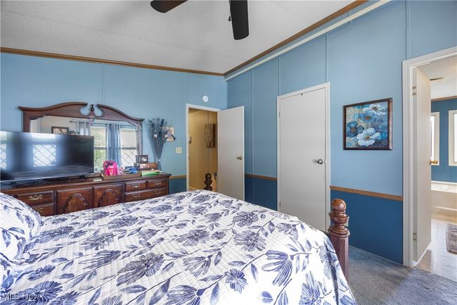 Bedroom featuring carpet, ornamental molding, ceiling fan, and connected bathroom | Image 37