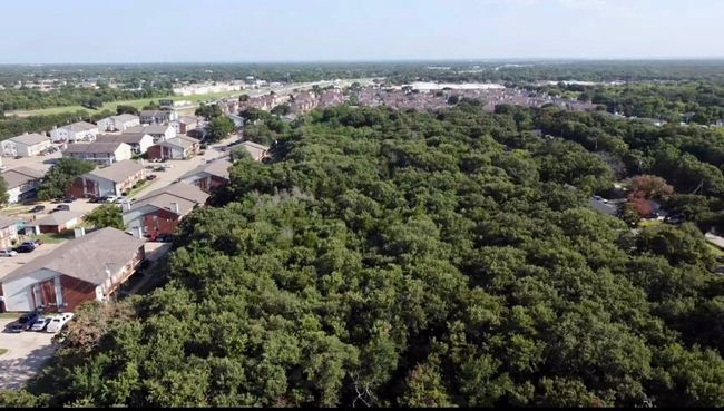 Aerial overview of property's location with nearby suburban area and a heavily wooded area | Image 4