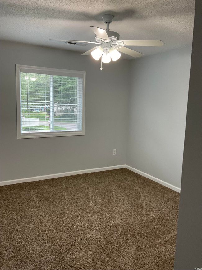 Carpeted spare room with ceiling fan and a textured ceiling | Image 11
