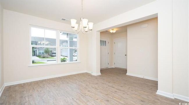 Empty room with a notable chandelier, baseboards, and wood finished floors | Image 7