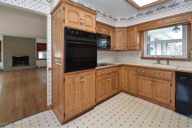 Kitchen featuring light floors, black appliances, a sink, and light countertops | Image 29