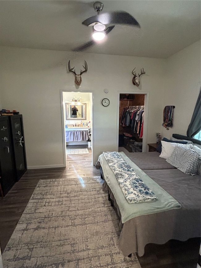 Bedroom featuring wood finished floors, a closet, and ceiling fan | Image 9
