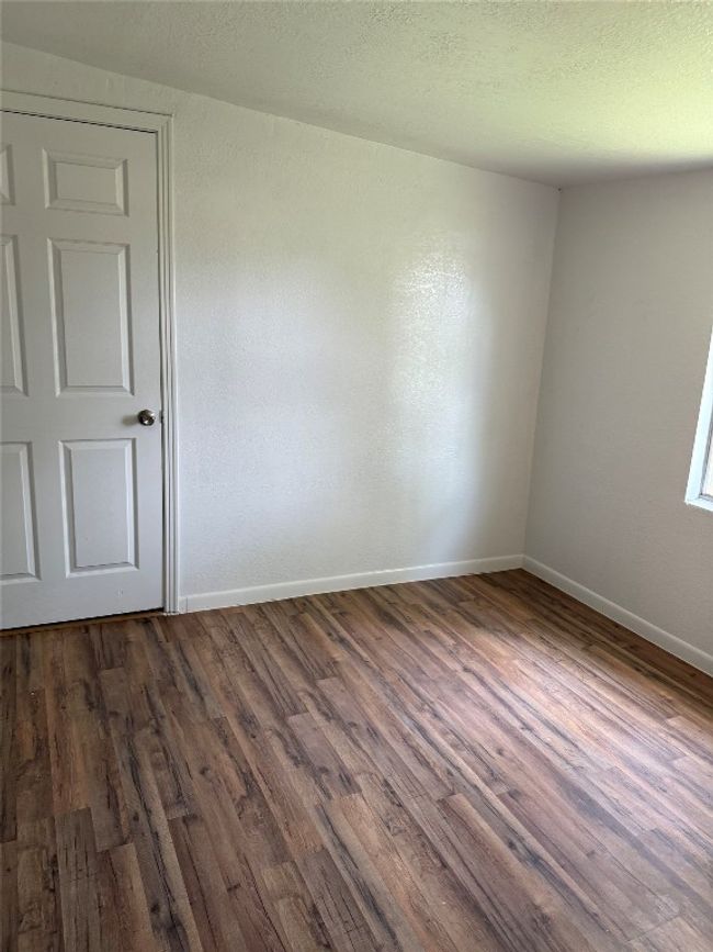 Spare room featuring dark wood-type flooring and baseboards | Image 5