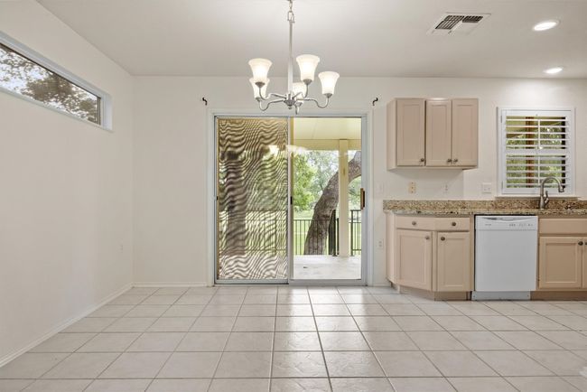 Unfurnished dining area featuring a chandelier, light tile patterned floors, and recessed lighting | Image 5