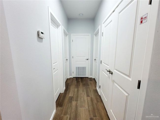 Hallway featuring dark wood-style floors and baseboards | Image 4