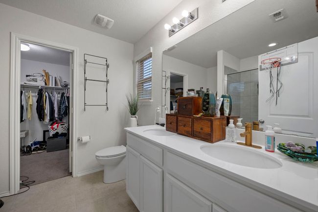 Full bathroom with visible vents, a shower stall, double vanity, a sink, and a spacious closet | Image 14