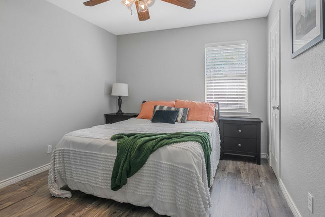 Bedroom with wood finished floors, baseboards, a ceiling fan, and a textured wall | Image 17