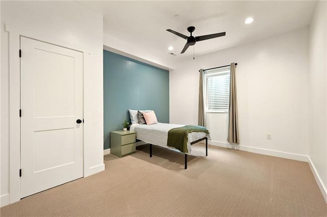 Downstairs lower level bedroom with carpeted floors and ceiling fan | Image 47