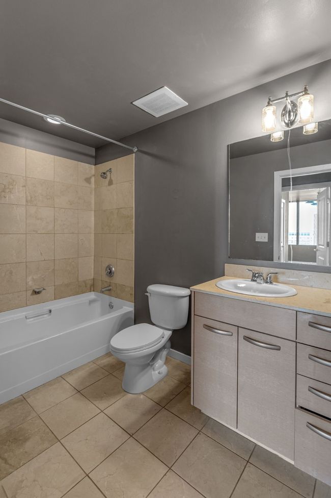 Full bath with toilet, visible vents, shower / washtub combination, tile patterned flooring, and vanity | Image 13