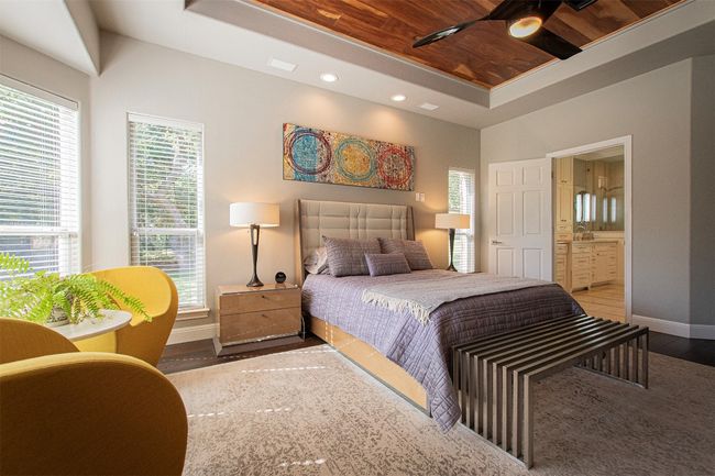 Bedroom with baseboards, a raised ceiling, wood finished floors, ensuite bathroom, and recessed lighting | Image 18
