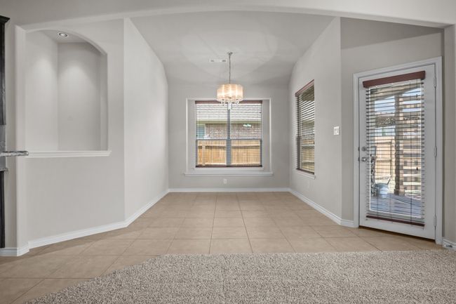 Unfurnished dining area featuring light tile patterned floors, baseboards, and a chandelier | Image 15