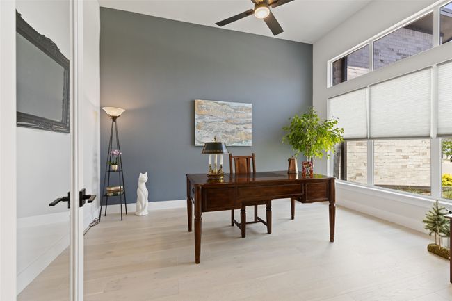 Home office featuring a wealth of natural light, light wood finished floors, baseboards, and a ceiling fan | Image 8