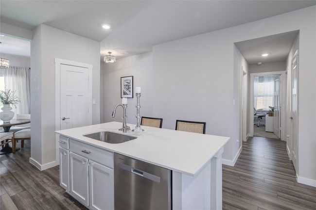 Kitchen featuring breakfast bar with hallway to secondary bedrooms | Image 12