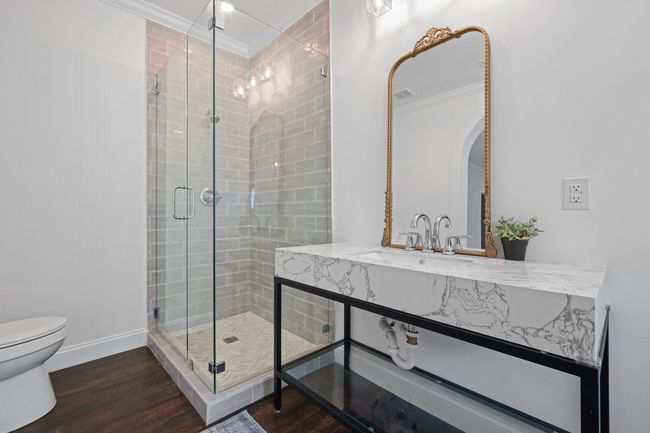 Bathroom with ornamental molding, a stall shower, wood finished floors, and vanity | Image 22