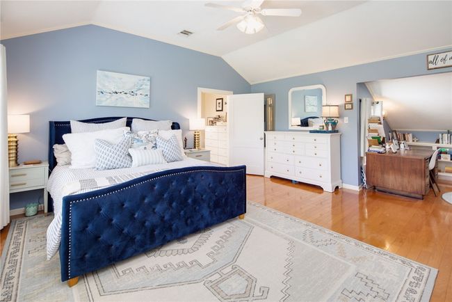 Bedroom featuring wood finished floors, lofted ceiling, and ceiling fan | Image 21