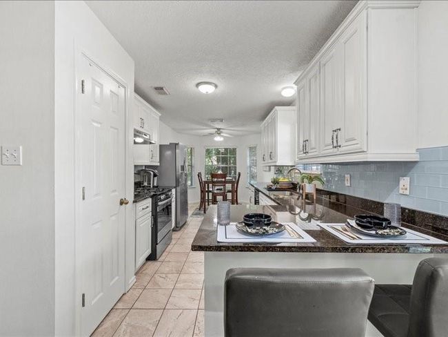 The kitchen offers plenty of cabinet space and a sweet breakfast nook ideal for morning coffee or casual meals. | Image 6
