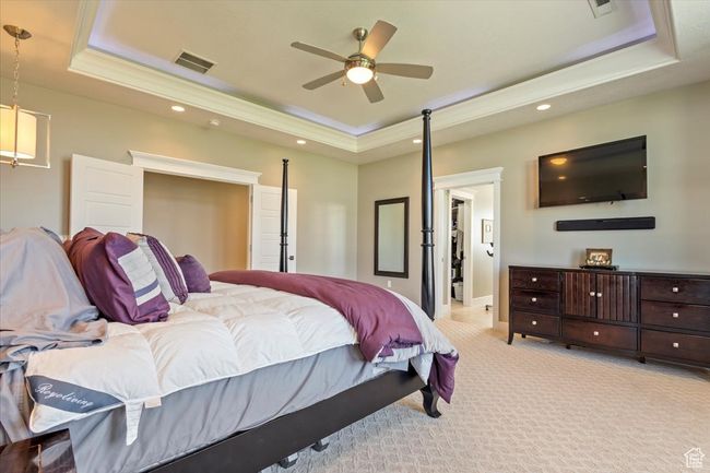 Bedroom featuring a tray ceiling, light carpet, recessed lighting, baseboards, and crown molding | Image 32